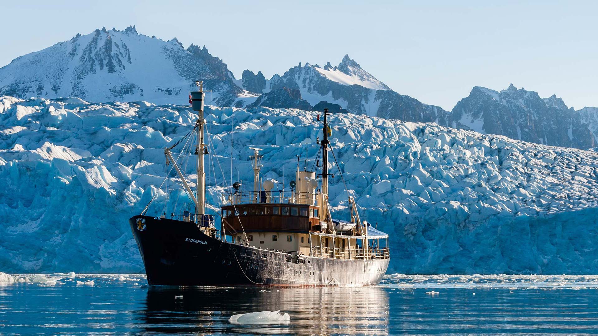 A photograph of the MS Stockholm against the backdrop of ice caps on a recent photo safari to Svalbard